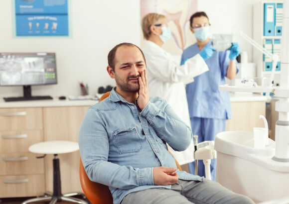 Sick patient complaining about teeth pain while waiting for dentists doctors